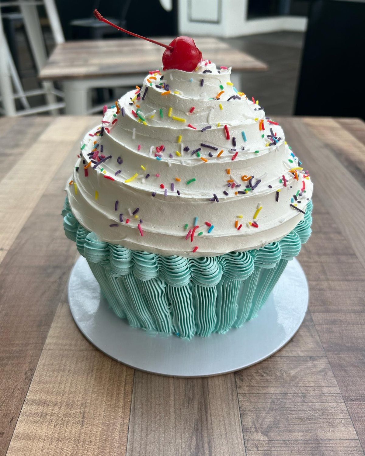 Quince Cake Ideas: 18 Designs From Florals to Butterflies 7 Giant cupcake cake with teal frosting base, white swirl topping, sprinkles, and a cherry.
