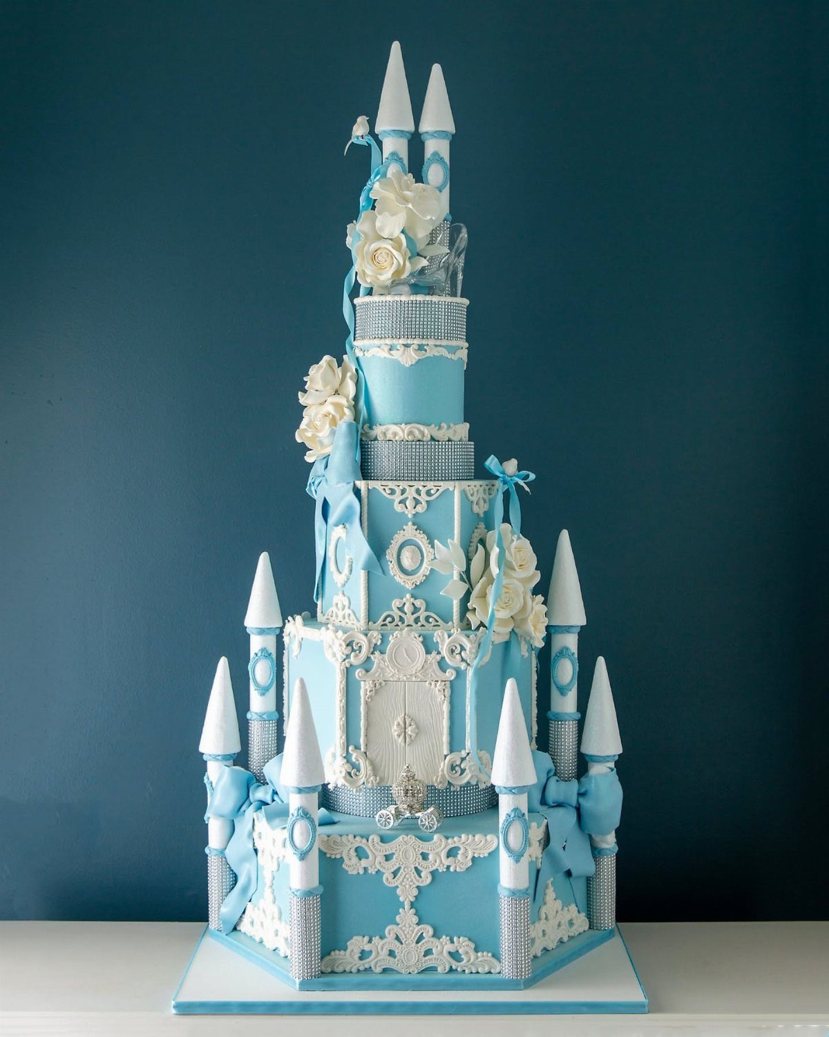 Quince Cake Ideas: 18 Designs From Florals to Butterflies 6 Light blue castle cake with white turrets, silver accents, and white roses.