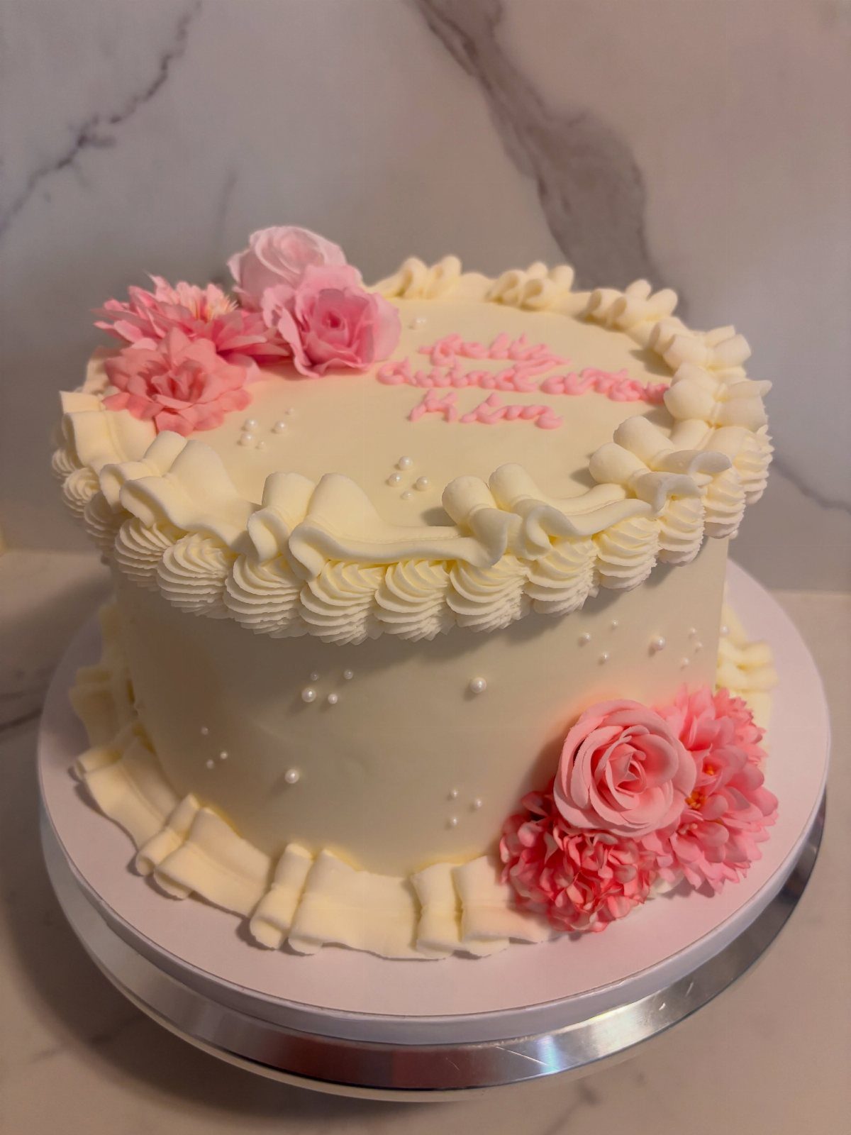 Quince Cake Ideas: 18 Designs From Florals to Butterflies 9 White frosted cake with pink roses, white ruffles, and small white edible pearls.