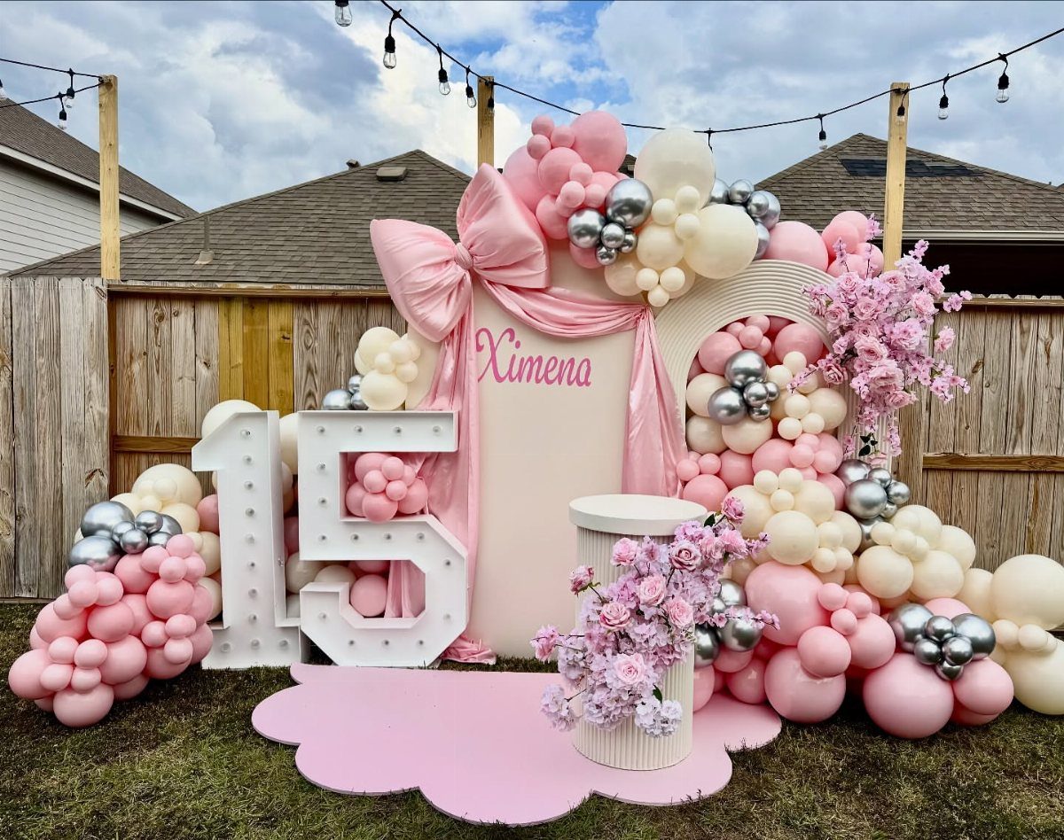 Pink and silver balloon archway next to a large light-up number 15 backdrop.