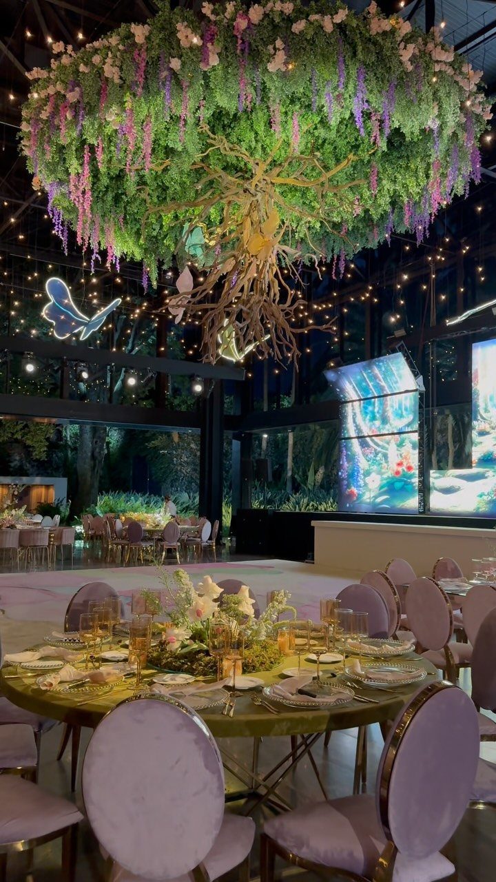 Large suspended floral tree with greenery and fairy lights over a decorated banquet table
