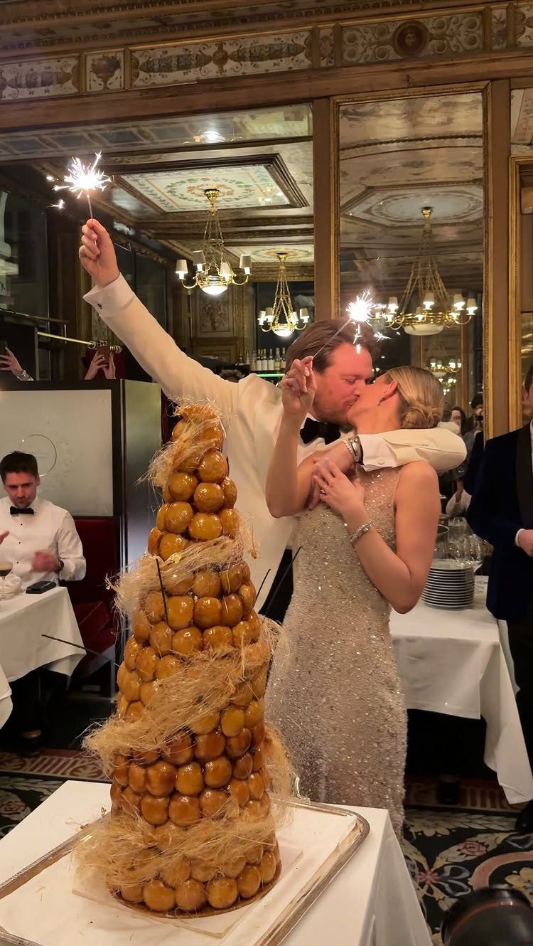 38 Romantic Wedding Cake Ideas for Your Celebration 39 Croquembouche tower of cream puffs with spun sugar beside a kissing wedding couple.