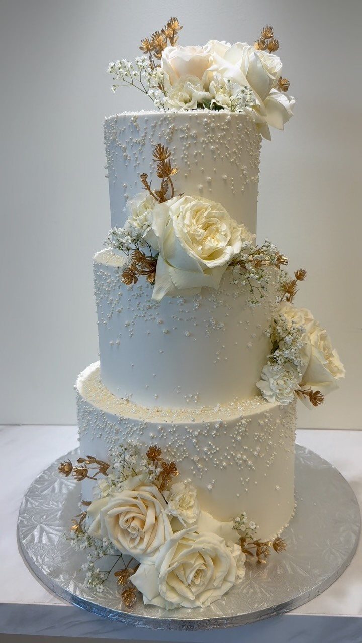 38 Romantic Wedding Cake Ideas for Your Celebration 2 Three-tier white wedding cake adorned with fresh white roses and edible pearls.