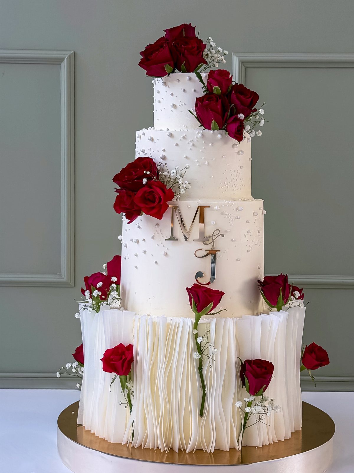 38 Romantic Wedding Cake Ideas for Your Celebration 17 Four-tier white wedding cake with red roses and gold monogram letters M and J.