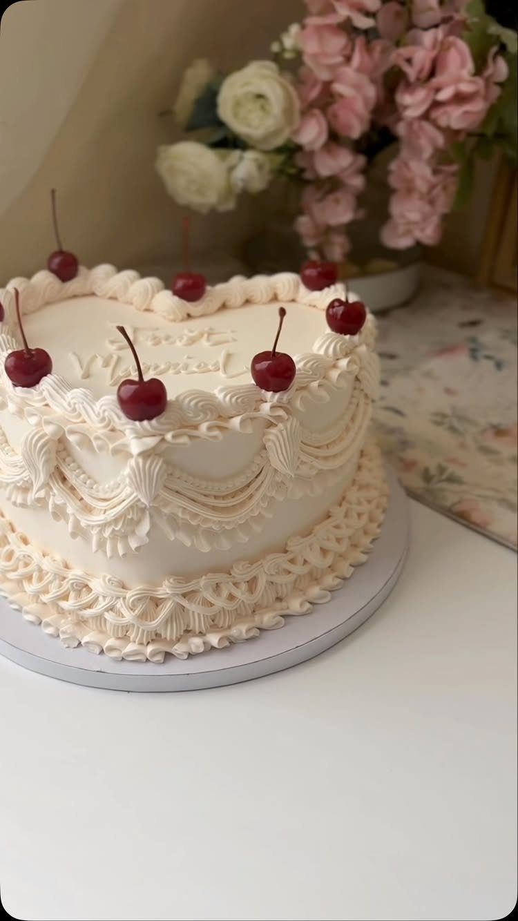 38 Romantic Wedding Cake Ideas for Your Celebration 19 Heart-shaped white vintage cake with ornate buttercream piping and fresh red cherries on top.