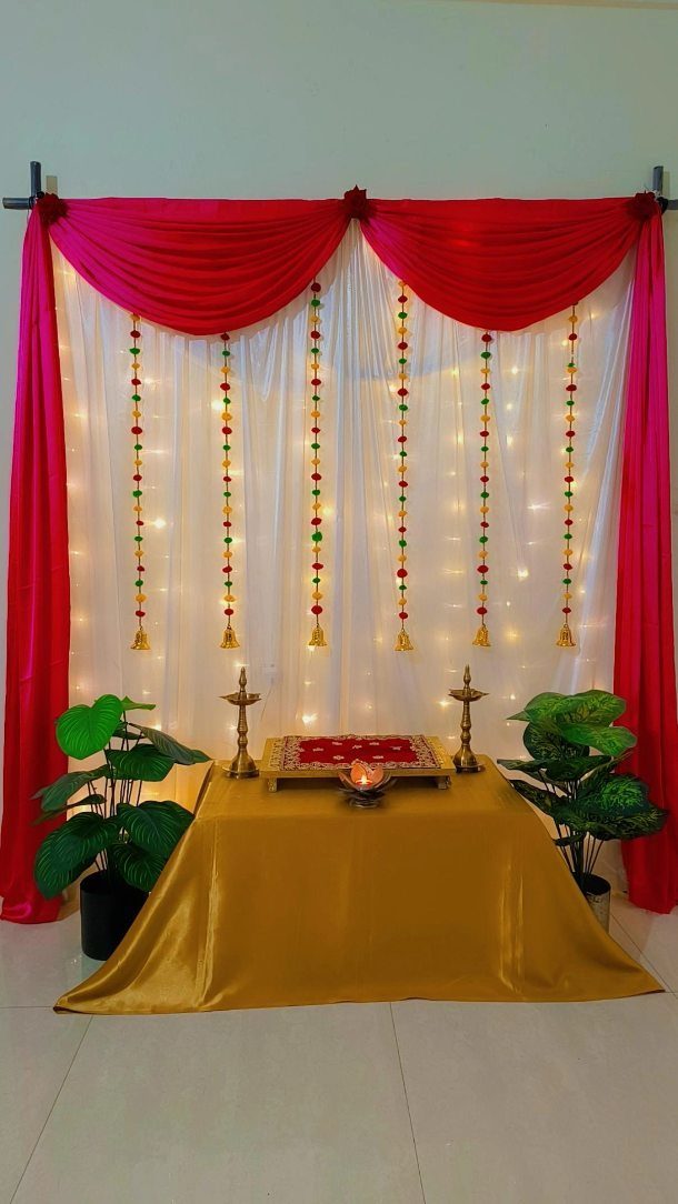 White and red saree backdrop with scallops, fairy lights, and a gold table.