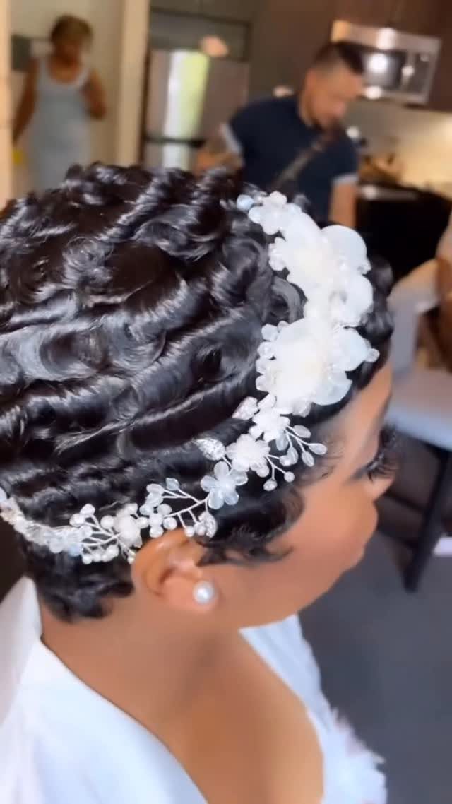 9 Short Curly Hairstyles for Wedding Day Perfection 4 Woman with short black finger waves wearing a white floral bridal headpiece.