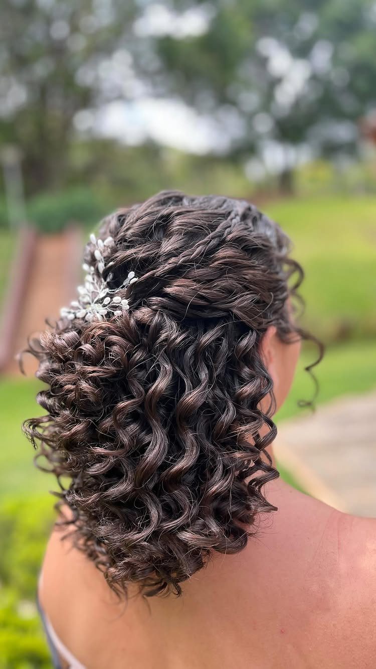 9 Short Curly Hairstyles for Wedding Day Perfection 7 Short dark curly hair styled in a half-updo with a silver sparkling accessory.