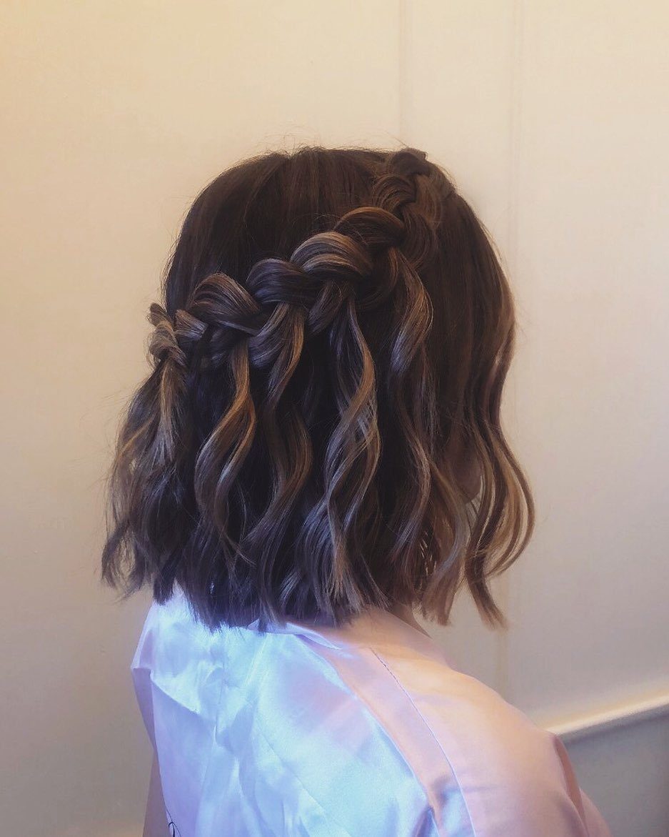 Short wavy brown hair styled with a thick braid along the side.