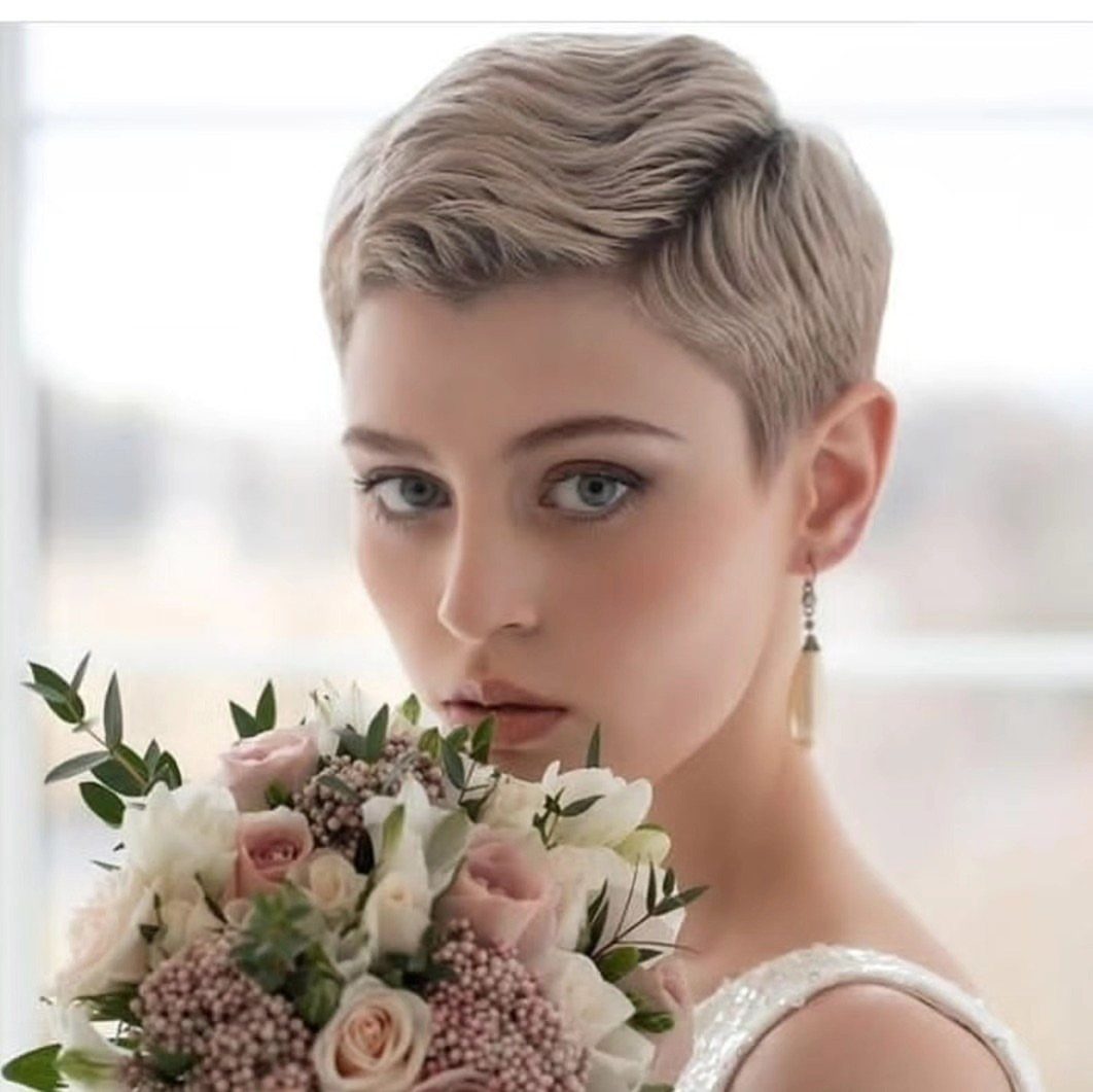 Woman with a blonde textured pixie haircut holding a bouquet of pink and white roses.