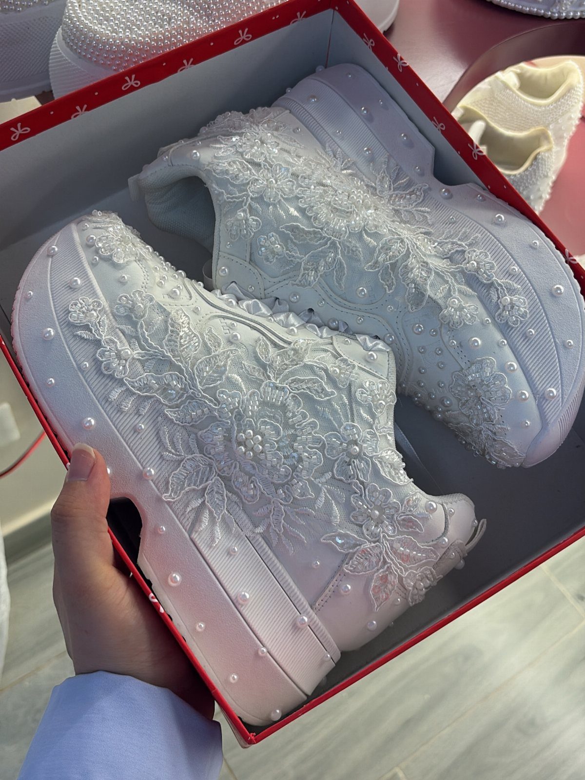 Sister Wedding Gift Ideas: 34 Picks She'll Treasure 11 White platform sneakers with lace and pearl embellishments inside a red box.