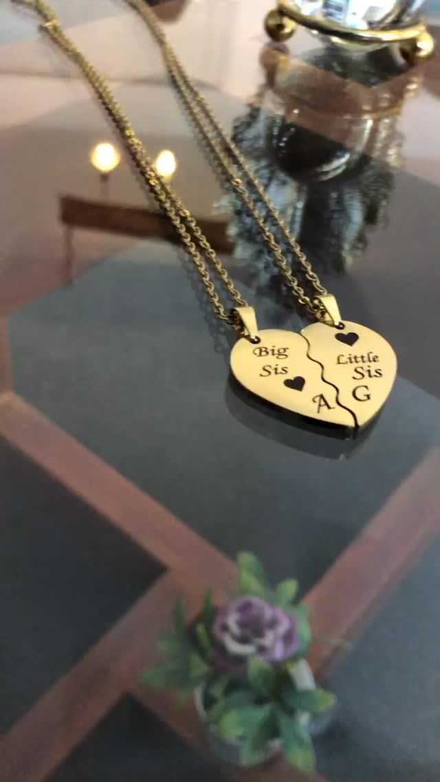 Sister Wedding Gift Ideas: 34 Picks She'll Treasure 17 Two gold heart-shaped necklaces engraved with Big Sis and Little Sis on glass.