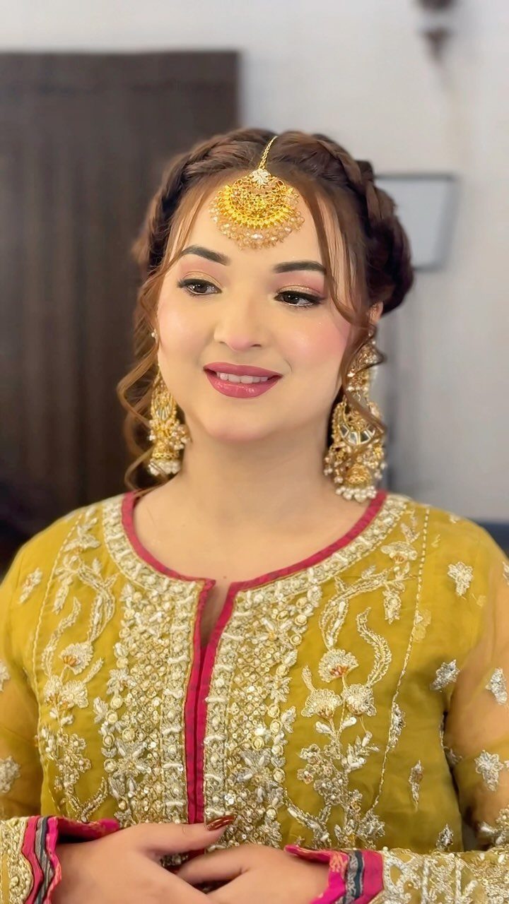 Sister Wedding Gift Ideas: 34 Picks She'll Treasure 20 Woman wearing ornate gold bridal earrings and a matching headpiece with yellow embroidery.
