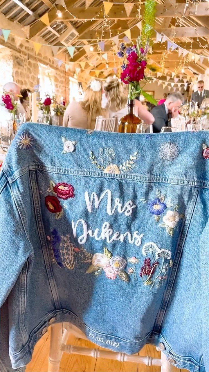 Sister Wedding Gift Ideas: 34 Picks She'll Treasure 2 Blue denim jacket with Mrs Dickens embroidery and colorful flowers at a wedding.