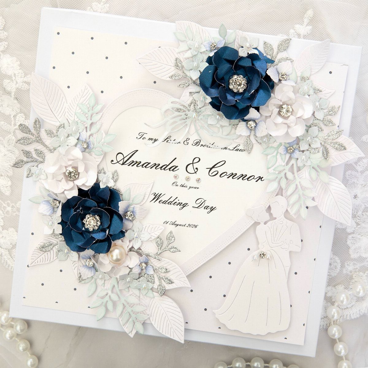 Sister Wedding Gift Ideas: 34 Picks She'll Treasure 9 Ornate white wedding card with blue paper flowers and silver leaf accents.