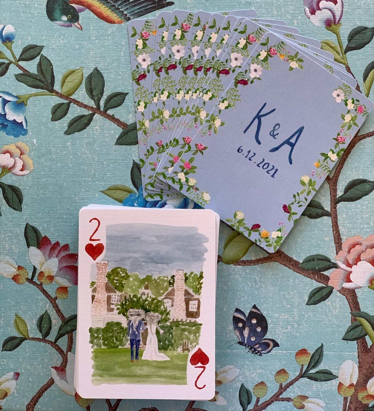 20 Small Wedding Gift Ideas for Couples Who Have Everything 16 Custom playing cards with a wedding illustration and personalized initials on a floral background.