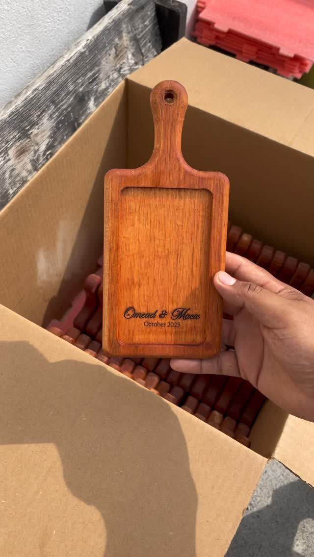 20 Small Wedding Gift Ideas for Couples Who Have Everything 3 Small wooden charcuterie board with engraved names and date held over a box.