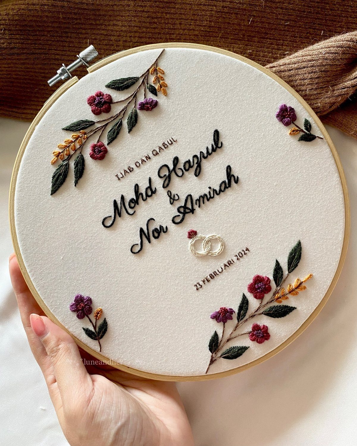 20 Small Wedding Gift Ideas for Couples Who Have Everything 14 Embroidered wedding name sign in a wooden hoop with floral accents and cursive text.