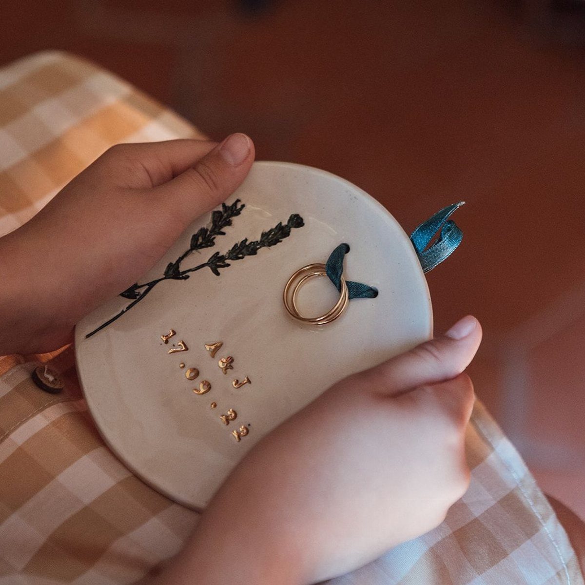 20 Small Wedding Gift Ideas for Couples Who Have Everything 6 Small white ceramic ring dish with gold rings, pressed lavender, and personalized gold lettering.