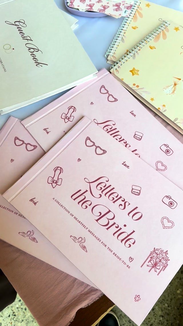20 Small Wedding Gift Ideas for Couples Who Have Everything 12 Pink Letters to the Bride keepsake books and a white wedding guest book.