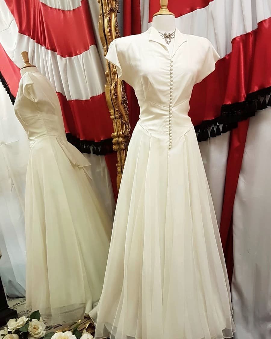 Vintage Elegant Wedding Dress Ideas in 12 Styles 9 White vintage A-line wedding dress with collared neckline and buttons on a mannequin.