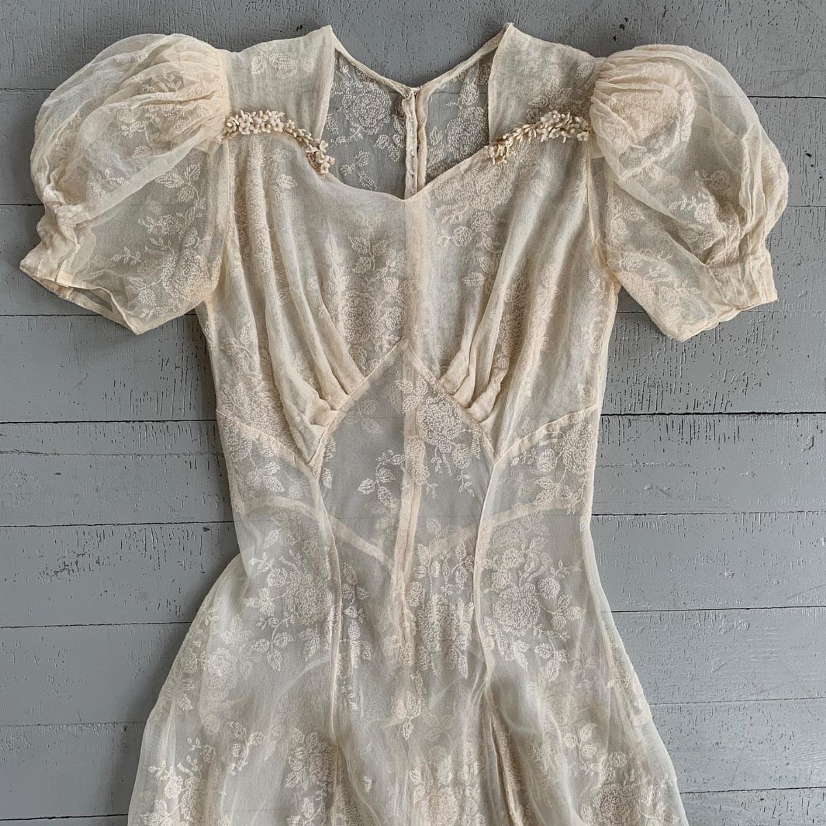 Vintage Elegant Wedding Dress Ideas in 12 Styles 10 Vintage cream lace wedding dress with short puff sleeves on grey wooden background.