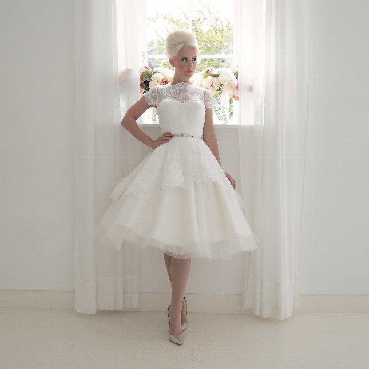 Vintage Elegant Wedding Dress Ideas in 12 Styles 6 Woman in a short white vintage wedding dress with a tiered tulle skirt.