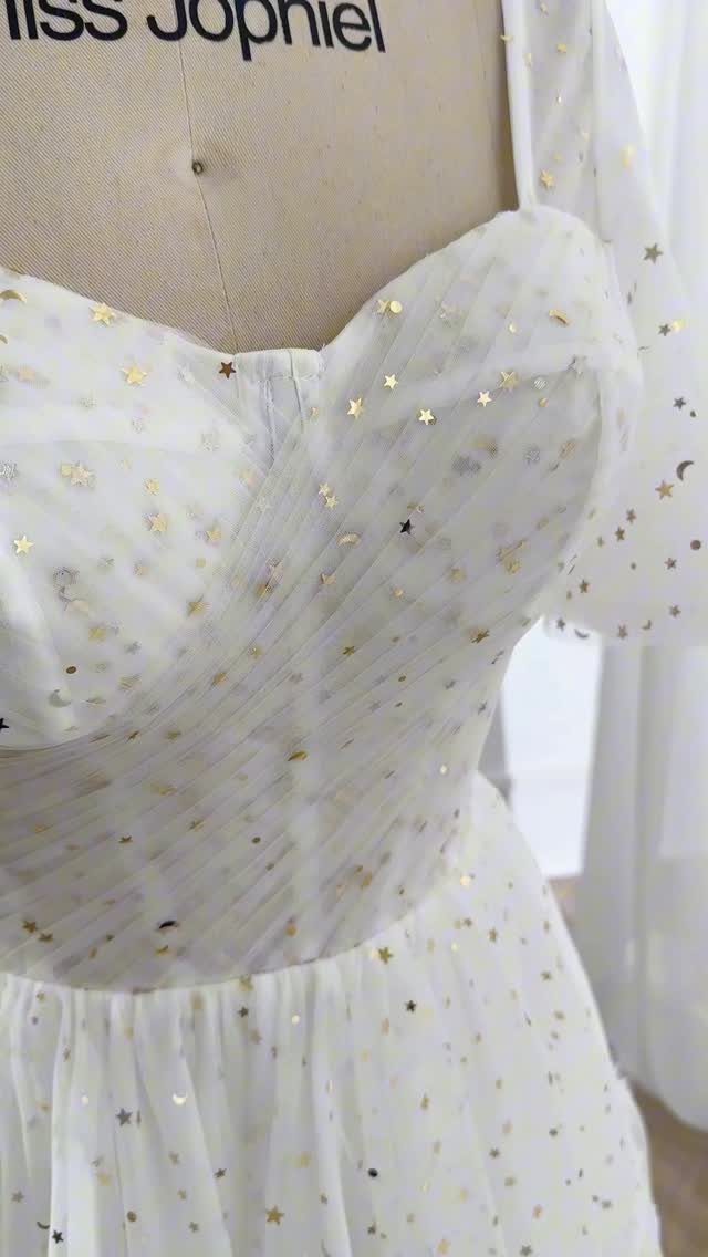 Vintage Elegant Wedding Dress Ideas in 12 Styles 13 White wedding dress with gold star sequins on a mannequin bodice