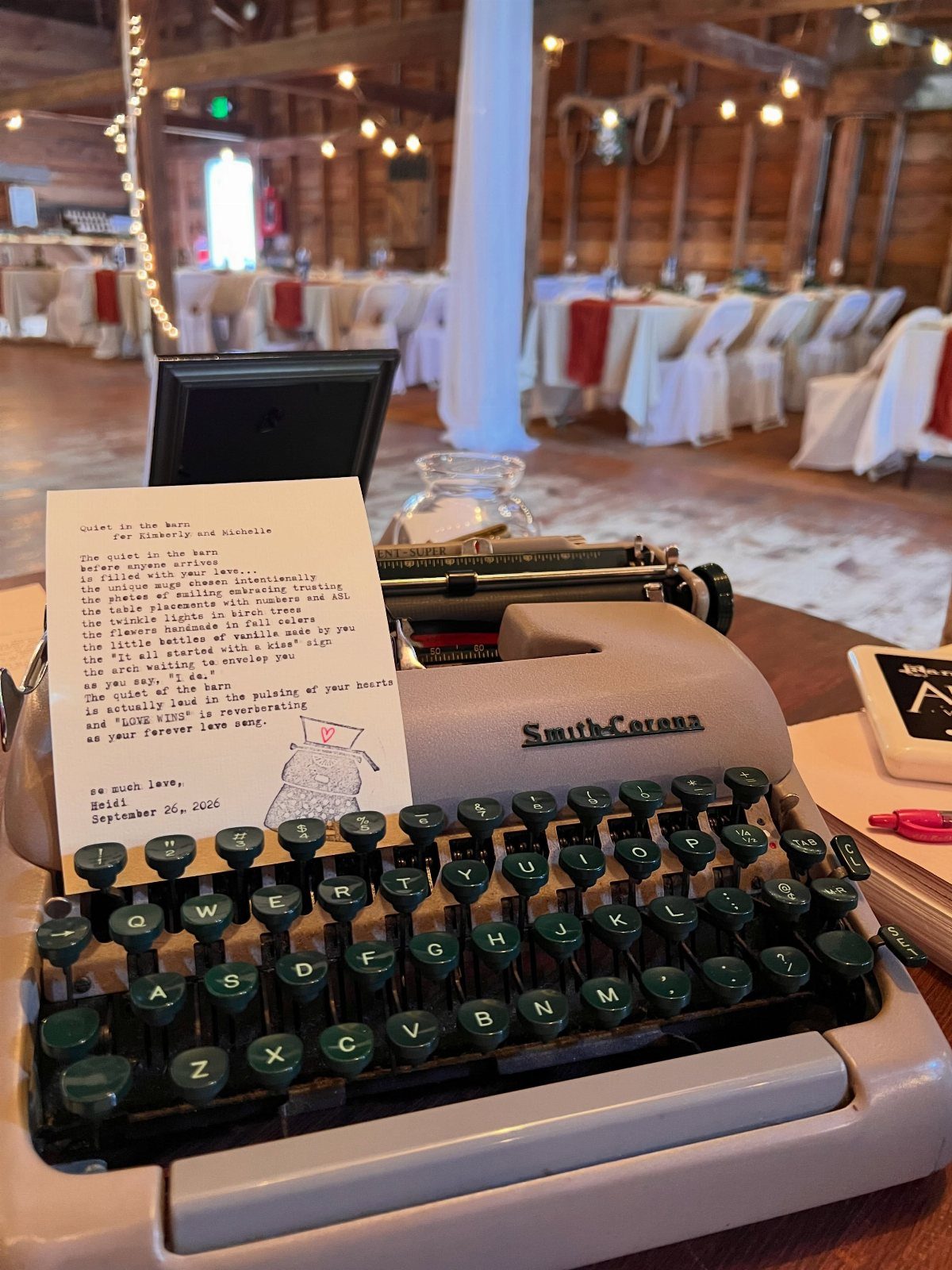 19 Wedding Activities for Guests: Reception Ideas Fun Enough to Fill the Whole Night 9 Vintage typewriter with a typed poem and small drawing on a wooden table in a rustic hall.