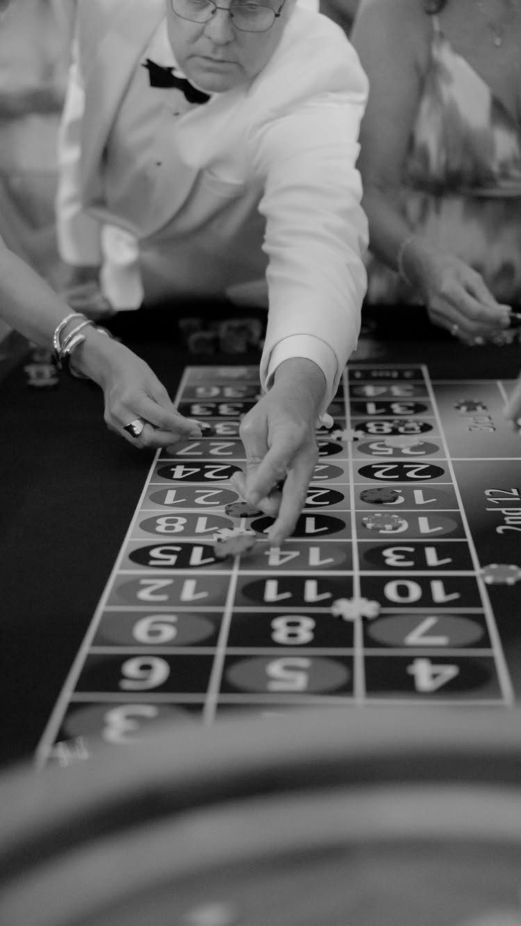 19 Wedding Activities for Guests: Reception Ideas Fun Enough to Fill the Whole Night 10 People playing roulette at a casino table with a man in a white tuxedo jacket.