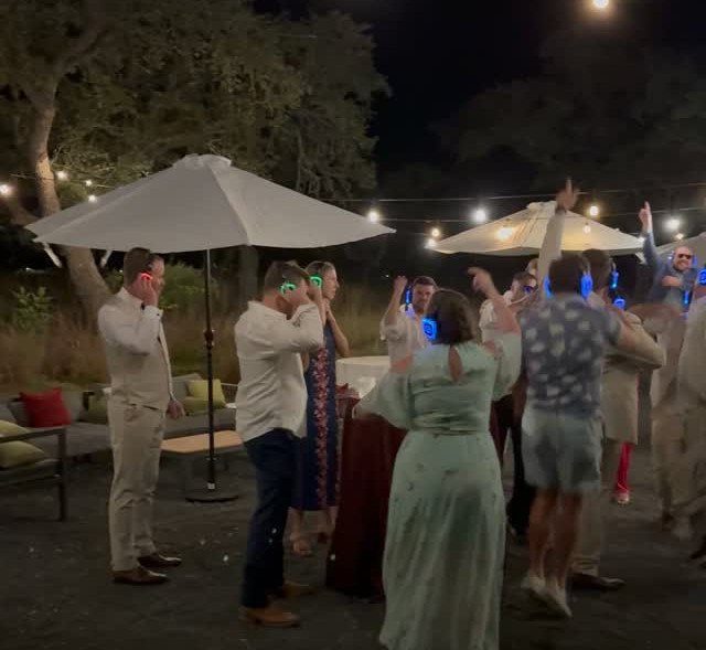 19 Wedding Activities for Guests: Reception Ideas Fun Enough to Fill the Whole Night 6 People dancing outdoors at night while wearing glowing blue wireless headphones during a silent disco.