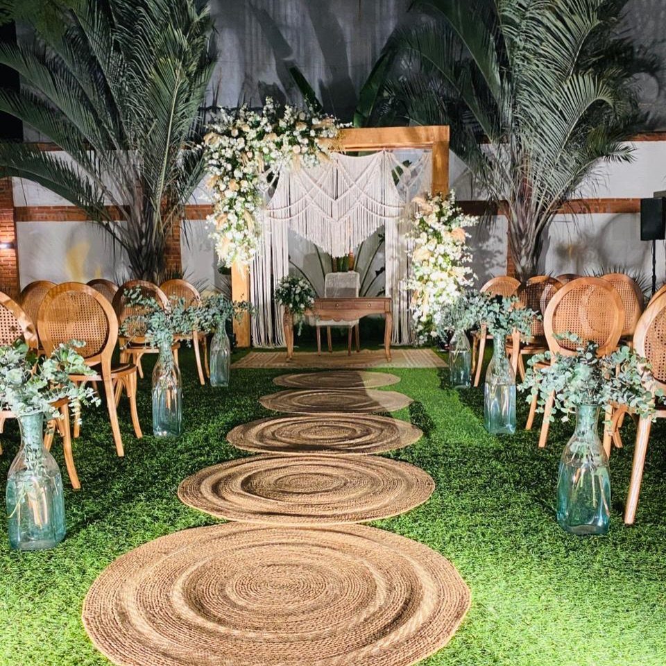 35 Backyard Wedding Reception Ideas for an Unforgettable Day 21 Wooden wedding arch with white macrame backdrop and floral arrangements on green grass.