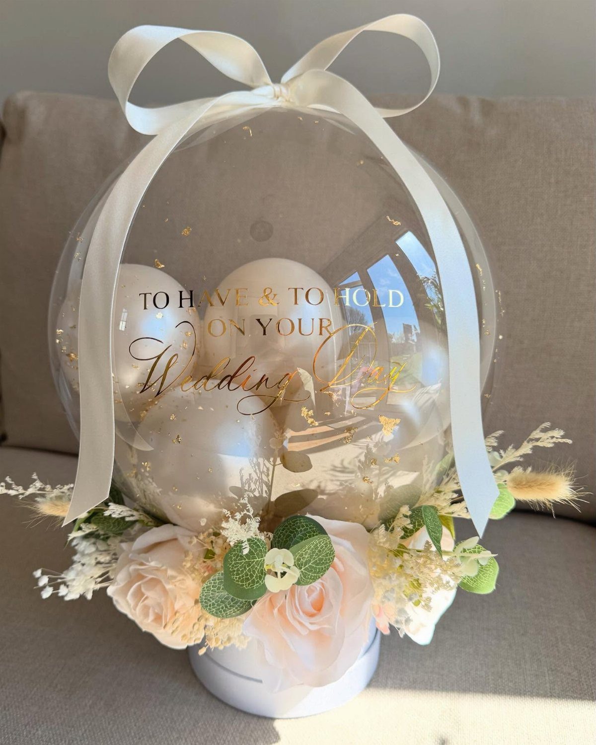12 Wedding Bouquet Alternatives for Your Big Day 7 Clear balloon filled with smaller balloons and topped with a white satin bow.