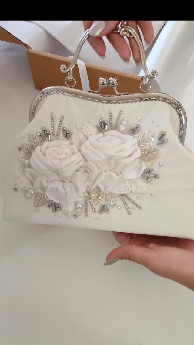 12 Wedding Bouquet Alternatives for Your Big Day 9 White bridal clutch bag featuring fabric roses and silver pearl embellishments.