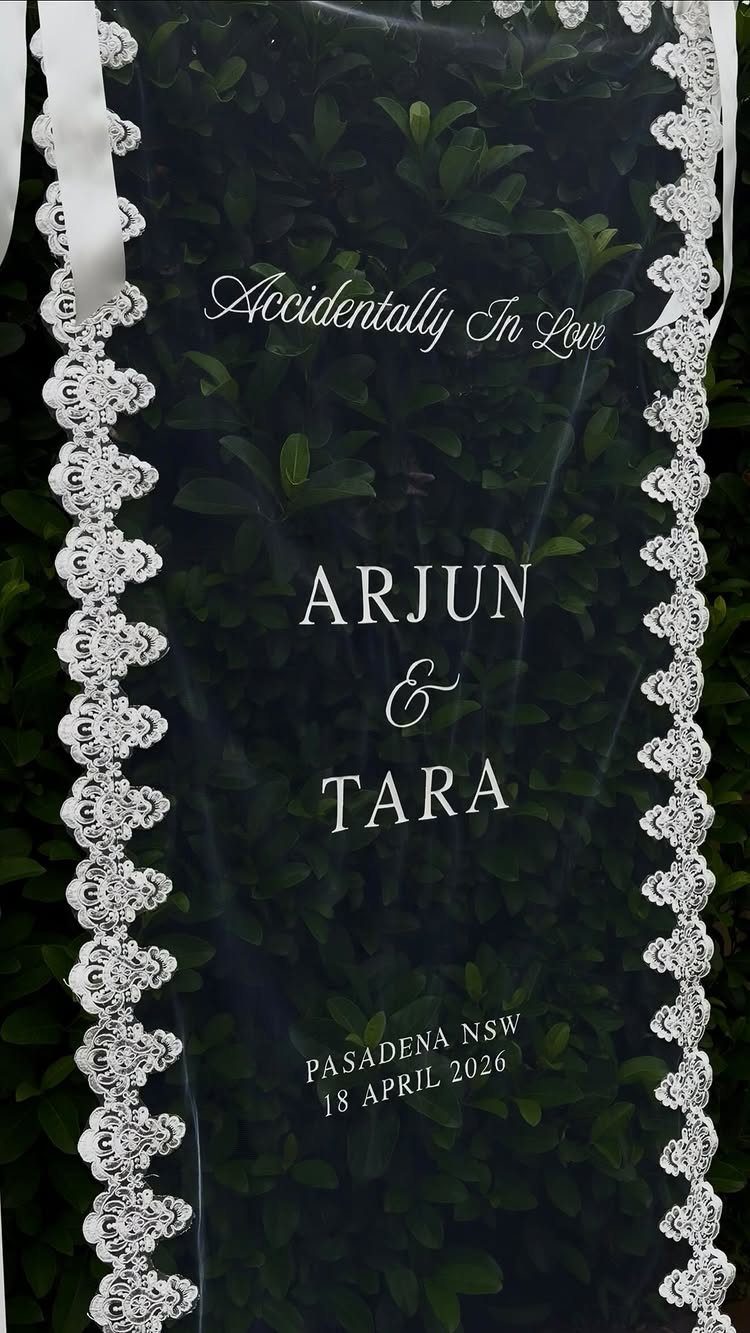 Wedding Decor Quotes: 7 Display Ideas From Letterboard to Acrylic 3 A transparent wedding sign with white text and lace trim hanging against green foliage.