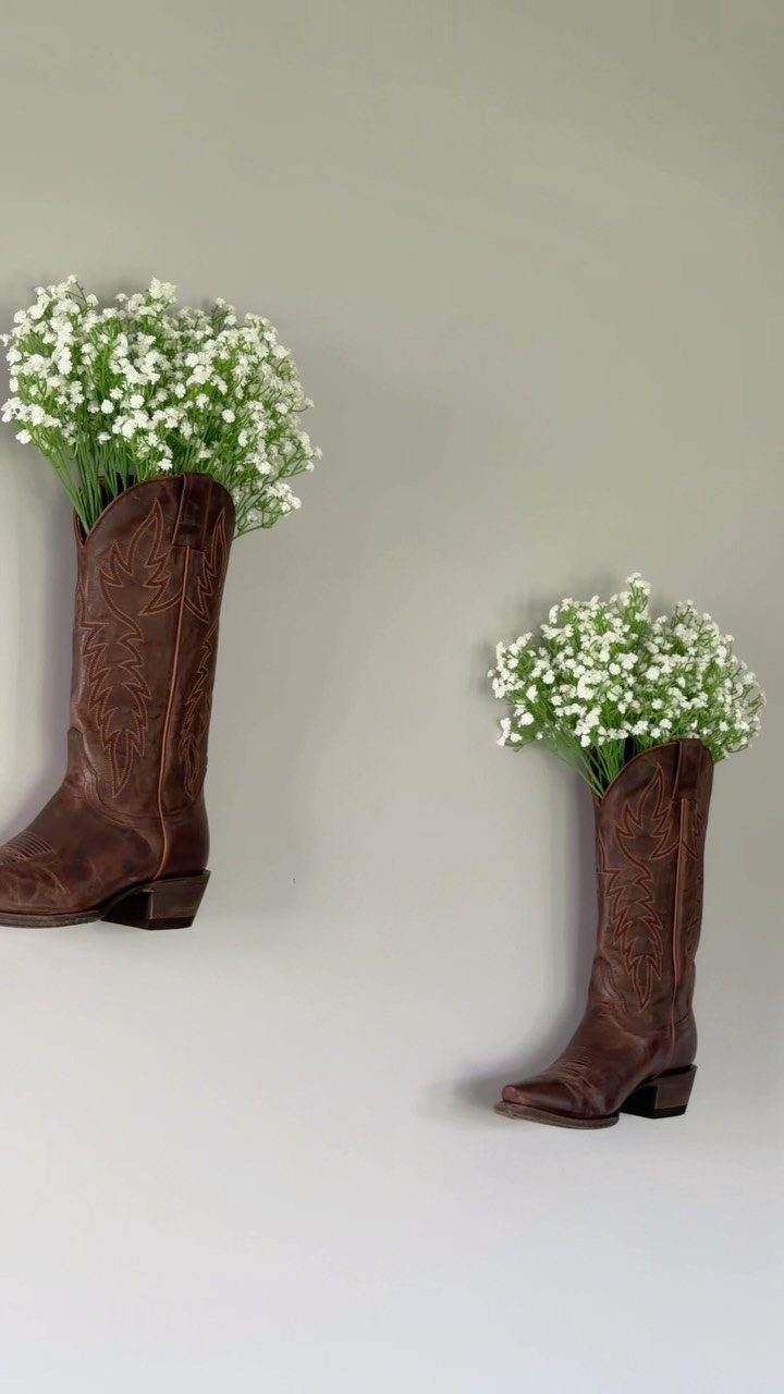 Wedding Decor with Western Style: 21 Ideas from Ranch to Aisle 3 Two brown cowboy boots filled with white baby's breath flowers against a grey wall.