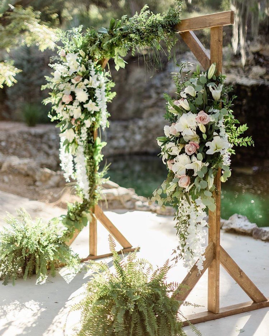 Wedding Decor with Western Style: 21 Ideas from Ranch to Aisle 2 A wooden wedding arch adorned with white and pink flowers and green foliage outdoors.