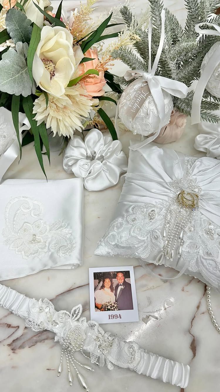 Wedding Detail Shots: 21 Ideas for Your Photographer 20 White wedding accessories including a bouquet, ring pillow, garter, and a vintage 1994 wedding photograph.