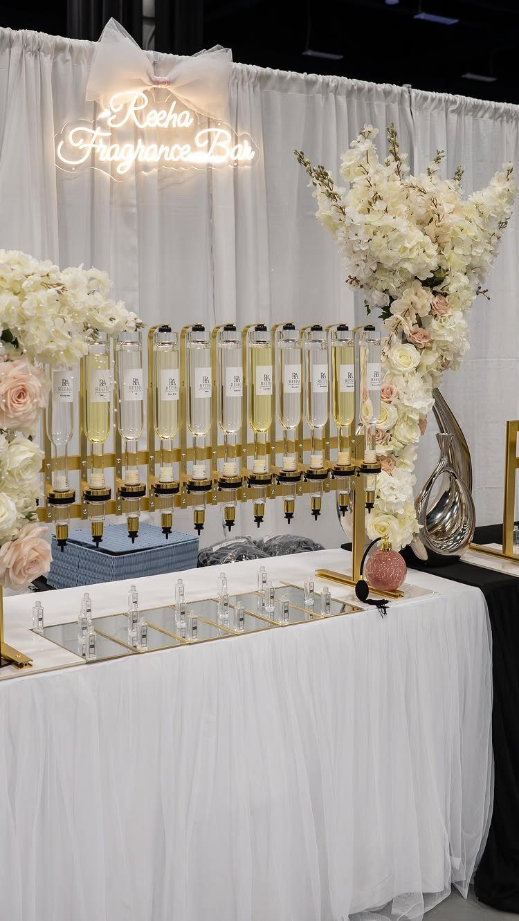 Wedding Detail Shots: 21 Ideas for Your Photographer 22 A gold fragrance bar dispenser with glass bottles sits on a white tablecloth decorated with flowers.