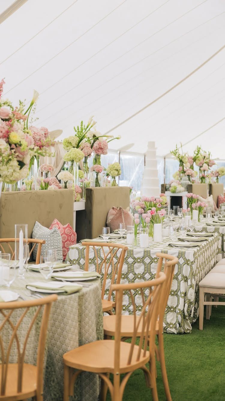 Wedding Detail Shots: 21 Ideas for Your Photographer 8 Wedding reception tables with patterned linens, floral arrangements, and wooden chairs under a white tent.