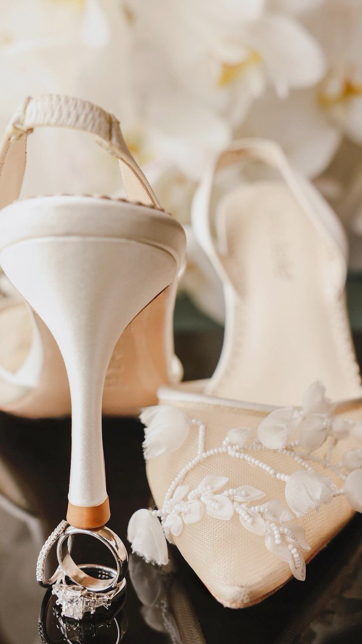 Wedding Detail Shots: 21 Ideas for Your Photographer 4 White embroidered bridal shoes with a wedding ring caught on the heel.