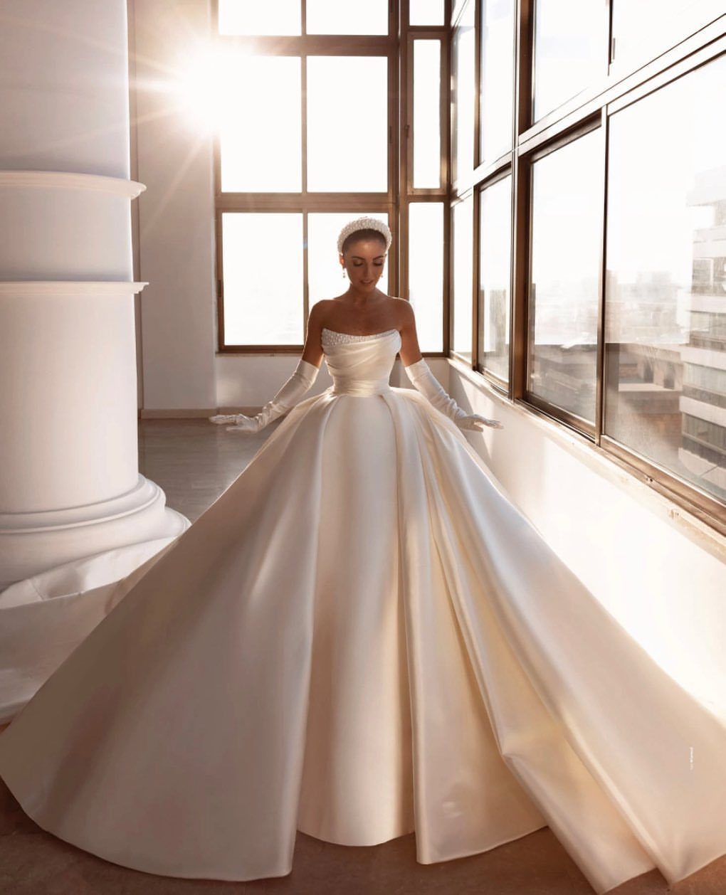Woman in a structured off-white duchess satin wedding gown with a full A-line skirt.