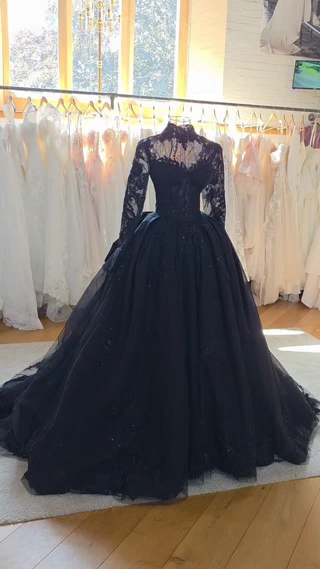 Black wedding gown with lace sleeves and full tulle skirt on a mannequin