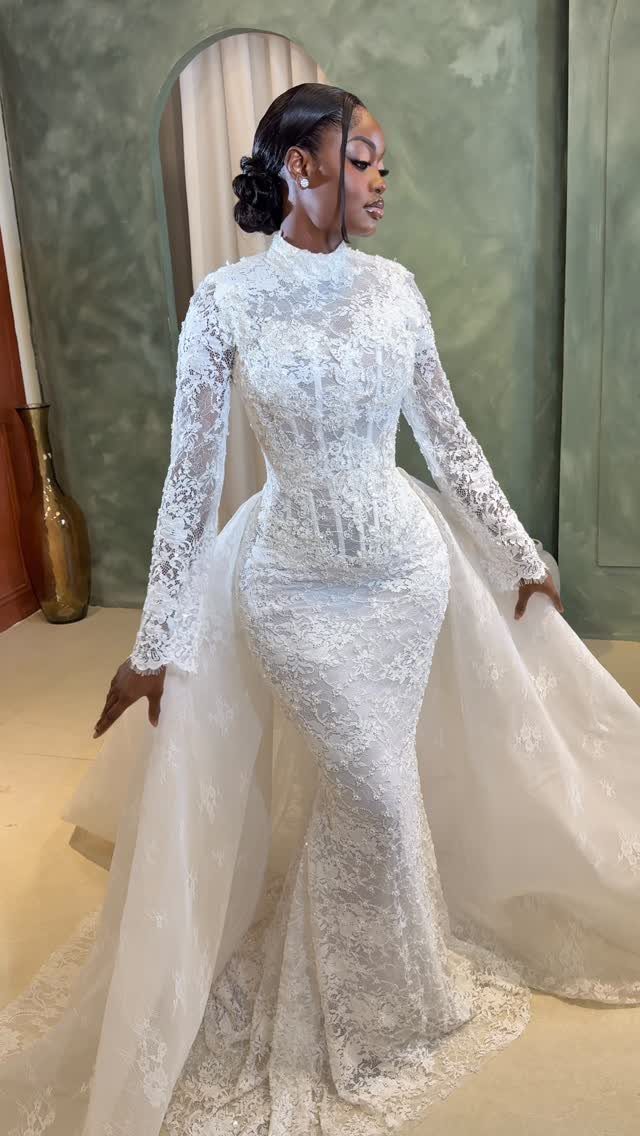 Woman in a white lace wedding gown with a long detachable train.