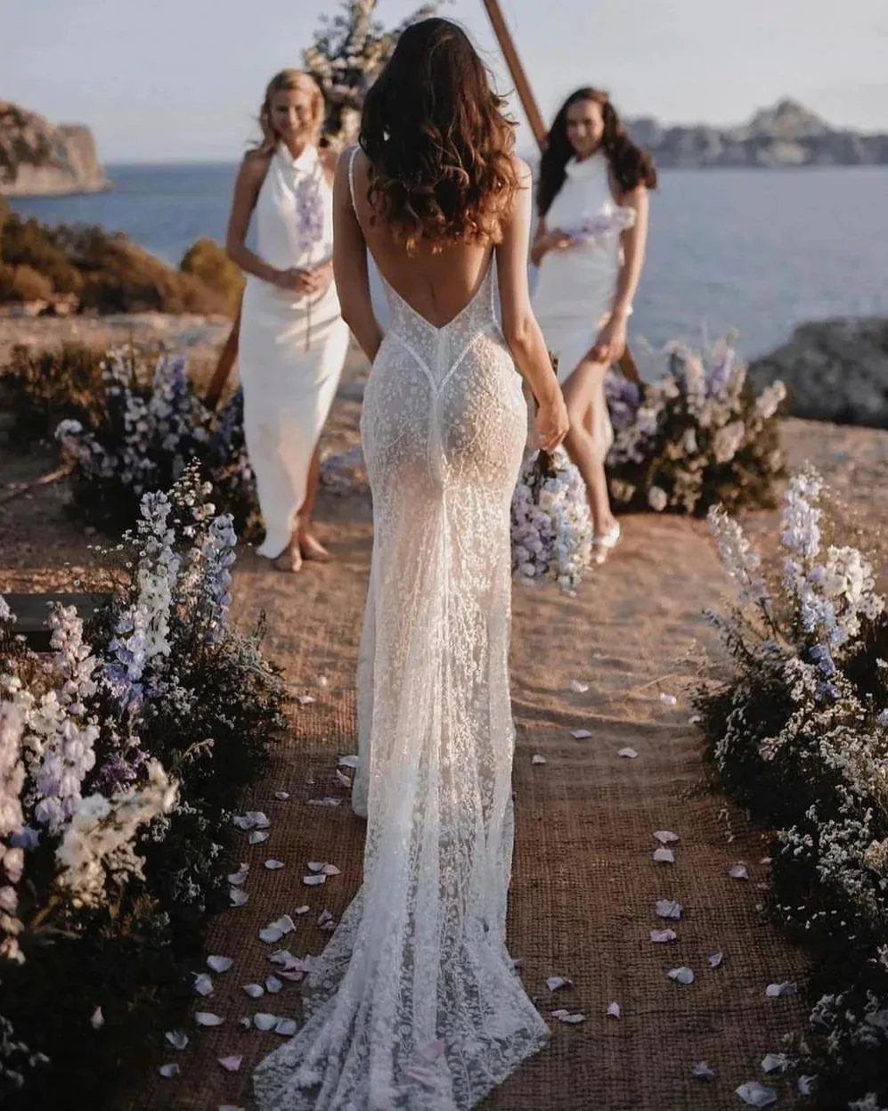 Tight Lace Wedding Dresses in 25 Beautiful Styles 20 Bride in a tight white lace wedding dress standing on a beach aisle.