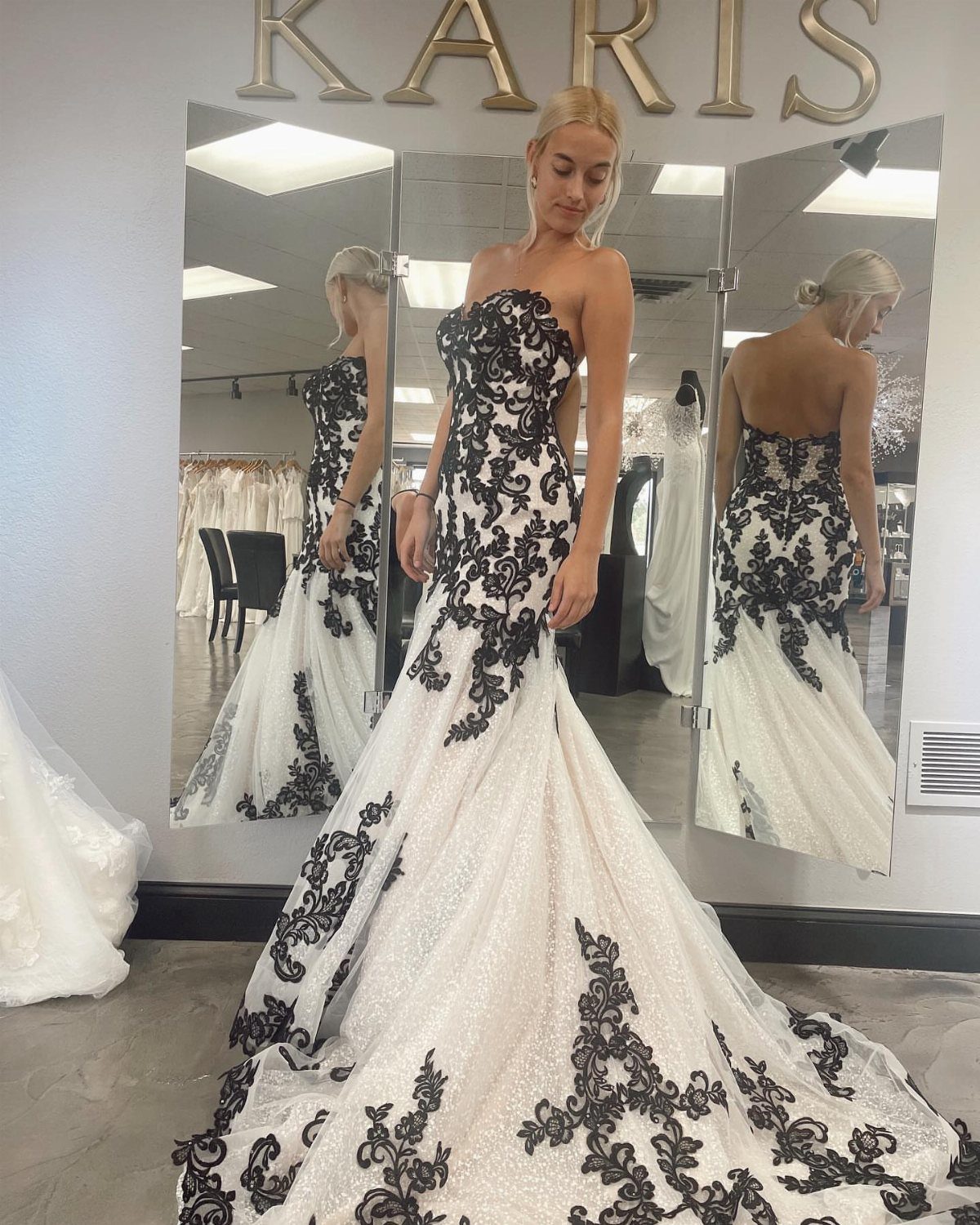 Tight Lace Wedding Dresses in 25 Beautiful Styles 22 Woman in a tight white wedding dress with black lace in a bridal shop.