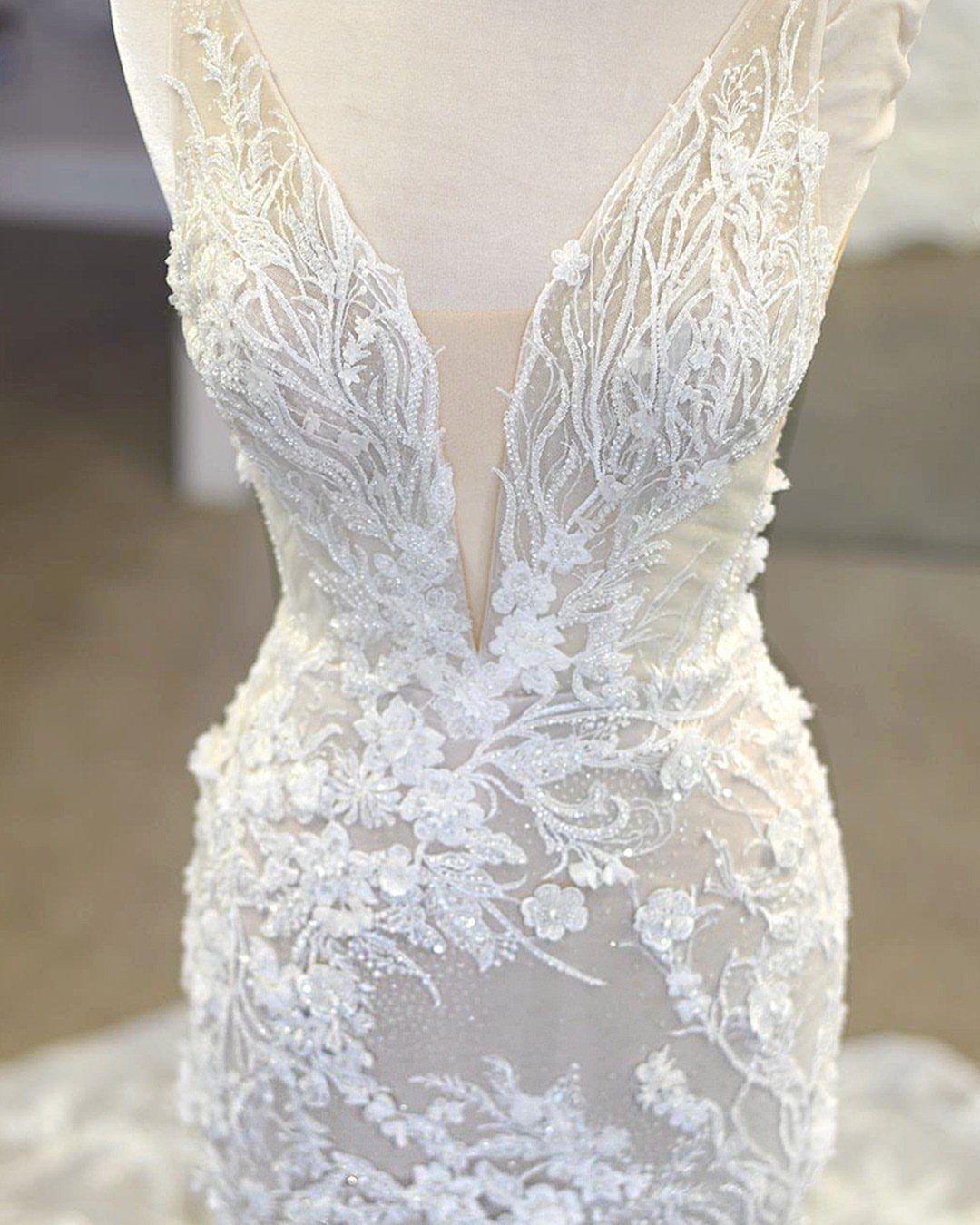 Tight Lace Wedding Dresses in 25 Beautiful Styles 24 White wedding dress with tight floral lace and a deep V-neckline on a mannequin
