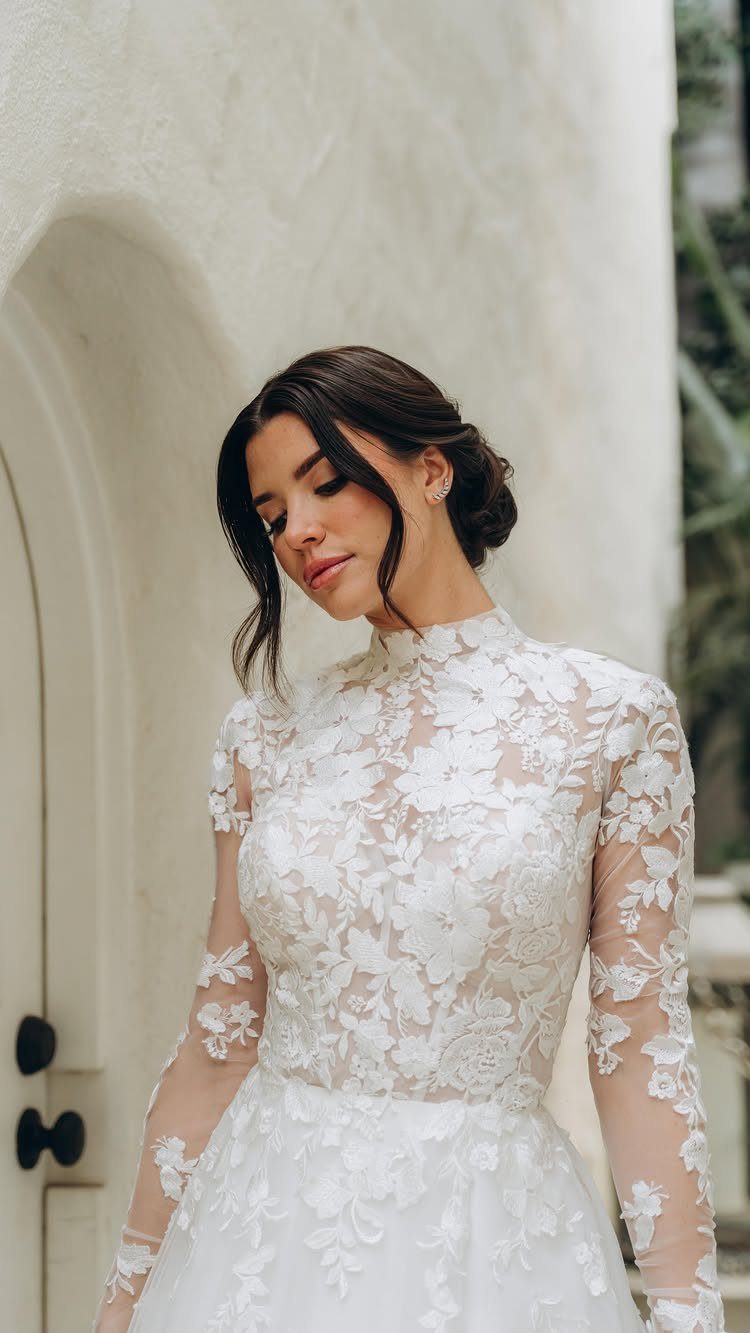 Tight Lace Wedding Dresses in 25 Beautiful Styles 12 Woman in a white long-sleeved wedding dress with intricate floral lace patterns.