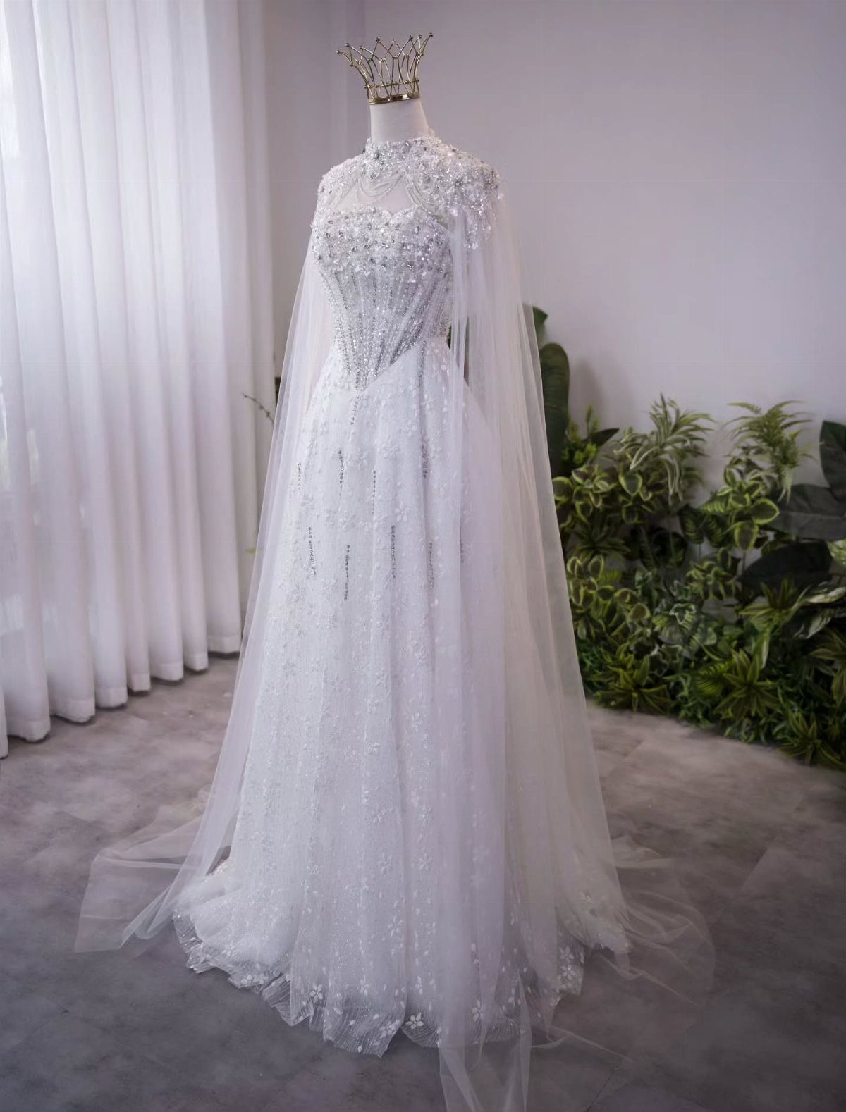 Tight Lace Wedding Dresses in 25 Beautiful Styles 15 White lace wedding dress on a mannequin with a sheer cape and gold crown.