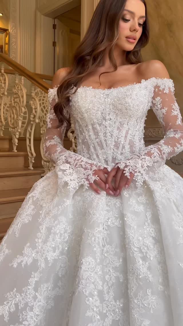 Tight Lace Wedding Dresses in 25 Beautiful Styles 9 Woman in a white lace corset wedding dress with long sleeves on a staircase.